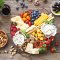 Cheese platter with fresh berries and nuts on a rustic wooden table