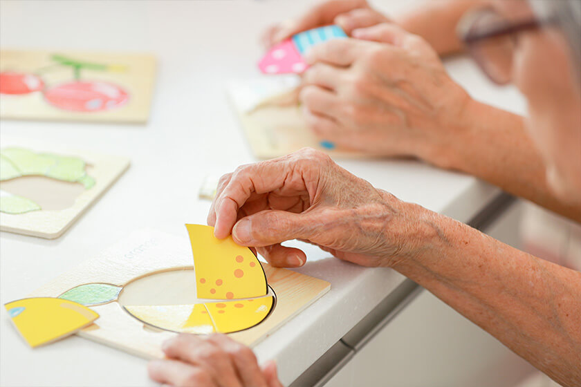 Hands of asian senior grandmother doing a jigsaw puzzle Hands of asian senior grandmother doing a jigsaw puzzle