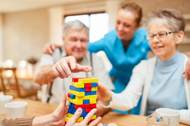 Seniors with dementia play with building blocks How Memory Care Center Can Help Increase Physical Activities In Dementia Patients