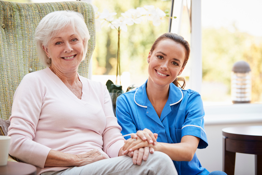 Portrait Of Senior Woman Sitting In Chair With Nurse In Retirement Home Some Qualities Of Team Members In White Rock Lake, TX Assisted Living