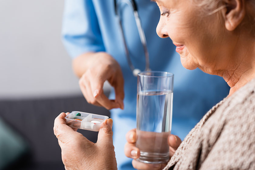 Nurse pointing with finger at pills in hand Nurse pointing with finger at pills in hand