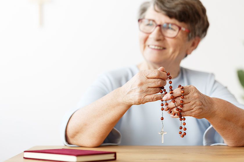 Person with rosary and bible Person with rosary and bible