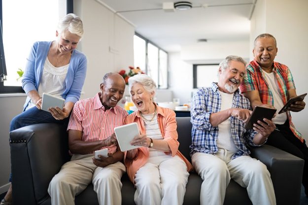 Senior friends showing digital tablet to each other Senior friends showing digital tablet to each other