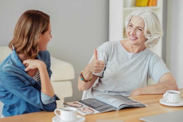 Cheerful aged woman resting with her daughter Cheerful aged woman resting with her daughter