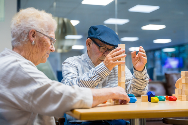 Pair of elder people in a nursing home playing skill games Pair of elder people in a nursing home playing skill games