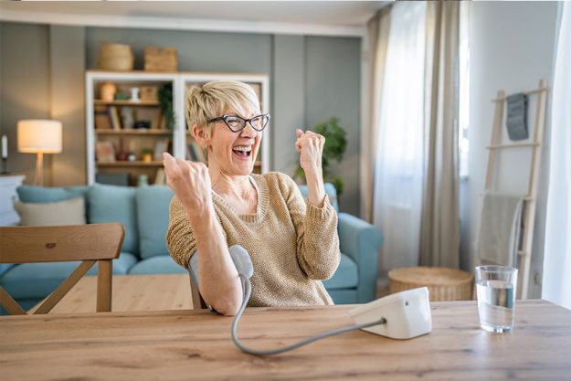 One woman senior caucasian female use blood pressure device hand One woman senior caucasian female use blood pressure device hand