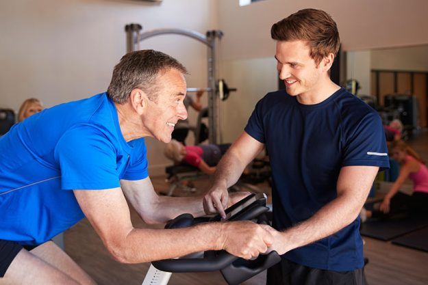 Senior Man Exercising On Cycling Machine Senior Man Exercising On Cycling Machine