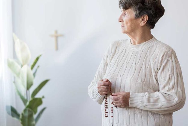 Religious-grandmother-praying-in-church Religious-grandmother-praying-in-church