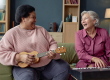 portrait-two-senior-women-laughing-playing-music-together