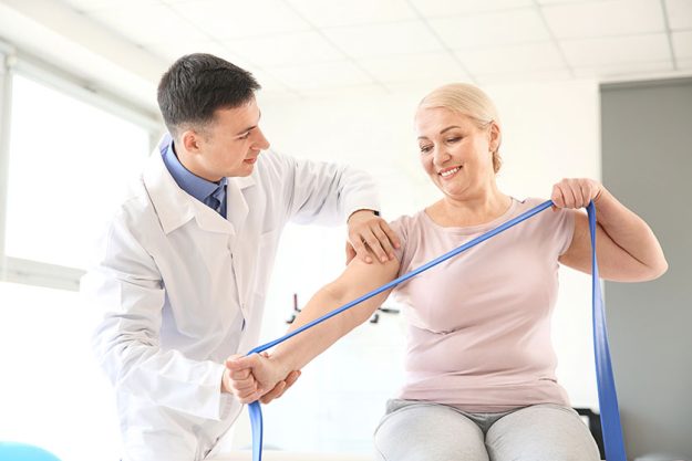 Physiotherapist working with mature patient Physiotherapist working with mature patient