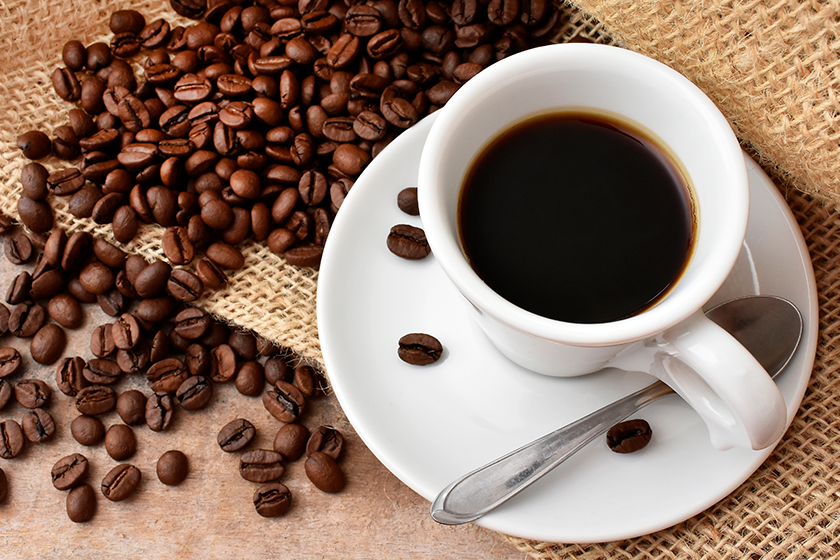 cup-coffee-beans Cup of coffee and beans on the table