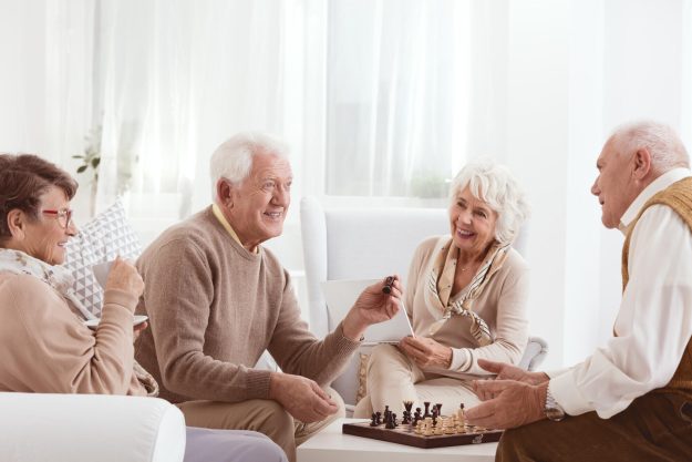 Group,Of,Happy,Seniors,Playing,Chess,Together